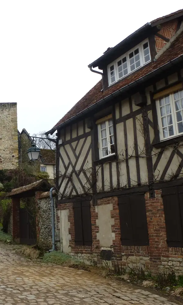 Gerberoy, rue du Château : maisons à pans de bois, murs de pierre et rue pavée jusqu’à l’ancienne porte
